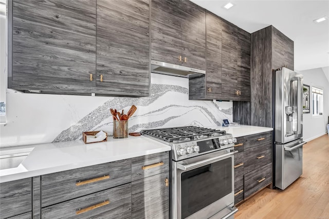 kitchen with stainless steel appliances, ventilation hood, backsplash, light hardwood / wood-style floors, and dark brown cabinets