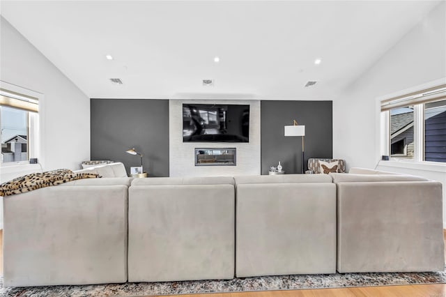 living room with a fireplace, hardwood / wood-style floors, and vaulted ceiling