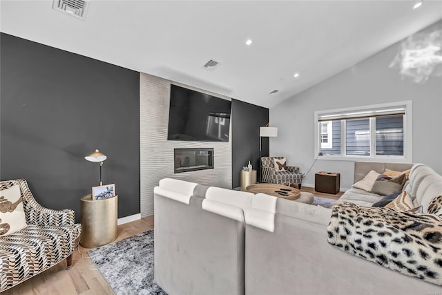 living room with light hardwood / wood-style floors and vaulted ceiling