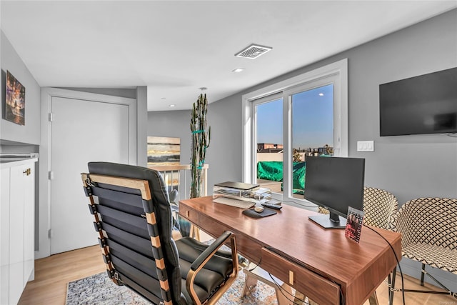 office with light hardwood / wood-style floors and lofted ceiling