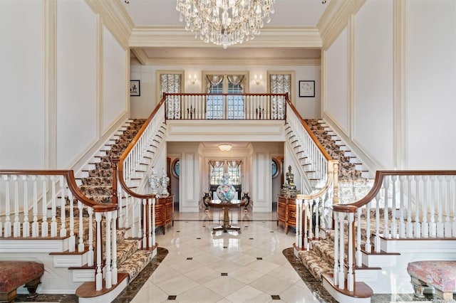 foyer featuring crown molding, a chandelier, and a high ceiling