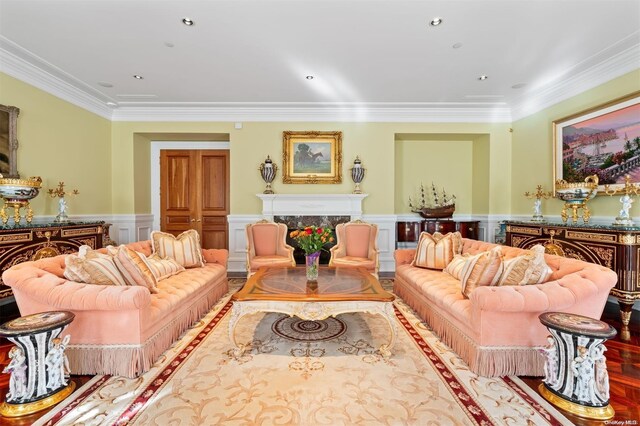 660 Chicken Valley Rd, Matinecock, NY 11560 - living area with crown molding, a high end fireplace, wainscoting, a decorative wall, and wood finished floors