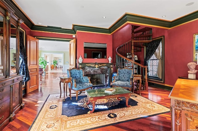 living room featuring crown molding, a fireplace, and hardwood / wood-style flooring