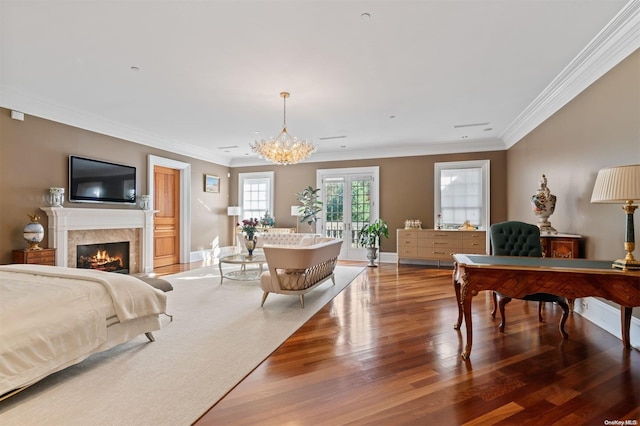 bedroom with crown molding, french doors, an inviting chandelier, and hardwood / wood-style flooring