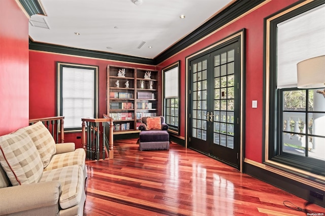 sitting room featuring french doors, built in features, ornamental molding, and hardwood / wood-style floors