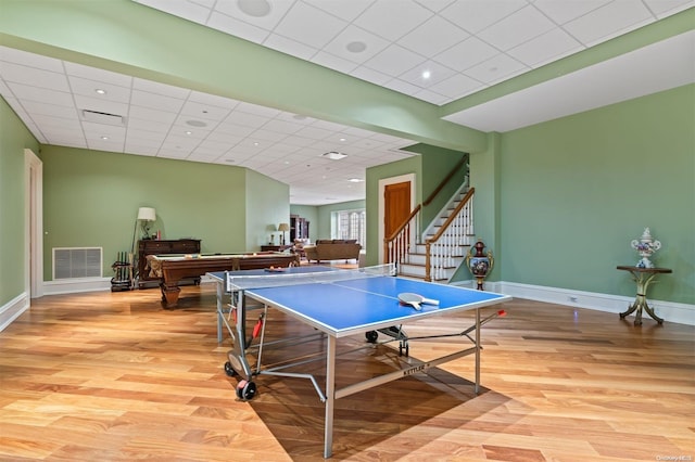 recreation room with light wood-type flooring and a paneled ceiling