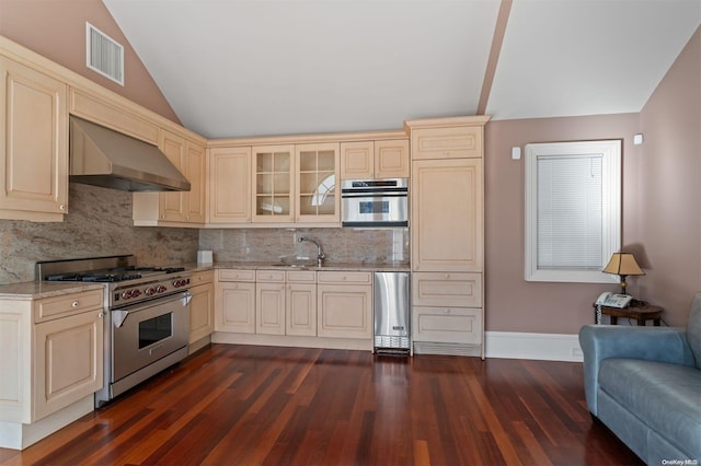 kitchen with appliances with stainless steel finishes, dark hardwood / wood-style flooring, lofted ceiling, and wall chimney range hood