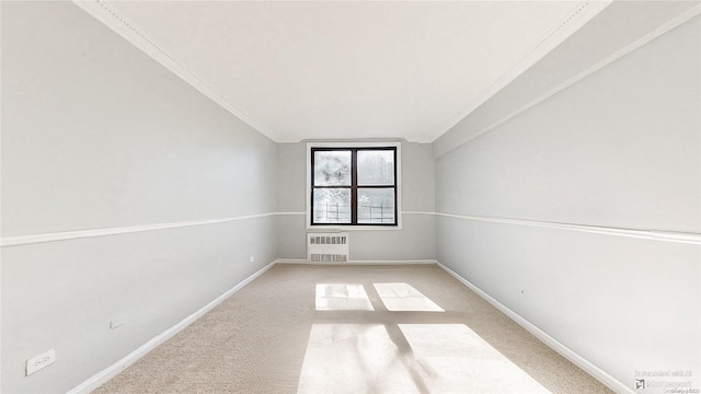 spare room with carpet flooring, crown molding, radiator, and lofted ceiling