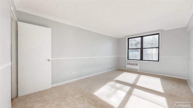 spare room with radiator heating unit, carpet floors, and ornamental molding