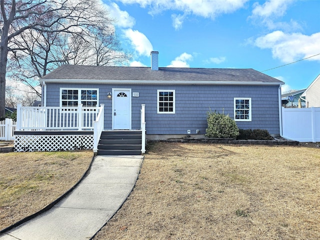 ranch-style home featuring a wooden deck and a front yard