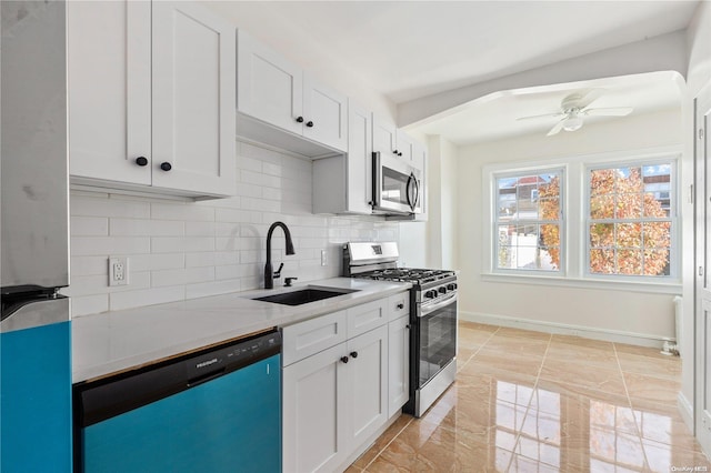 kitchen featuring white cabinetry, sink, ceiling fan, backsplash, and appliances with stainless steel finishes