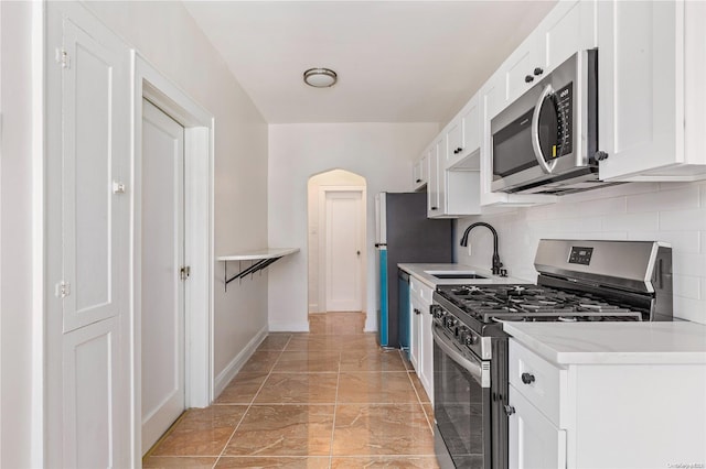 kitchen with white cabinetry, sink, appliances with stainless steel finishes, and tasteful backsplash