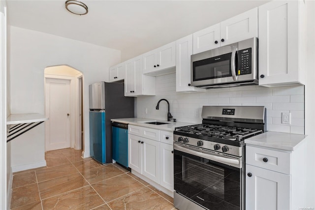 kitchen with backsplash, sink, white cabinetry, and stainless steel appliances