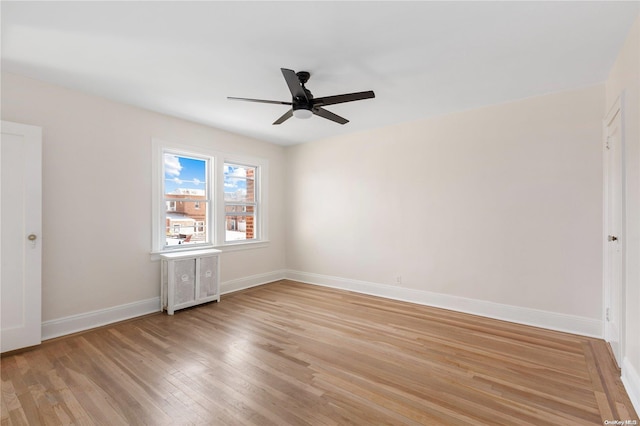 unfurnished room featuring radiator, light hardwood / wood-style floors, and ceiling fan