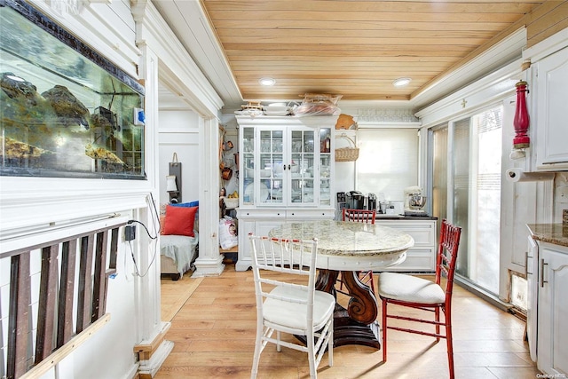 dining area featuring light wood-type flooring and wooden ceiling