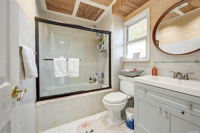 full bathroom featuring shower / bath combination with glass door, tile patterned floors, tile walls, and toilet