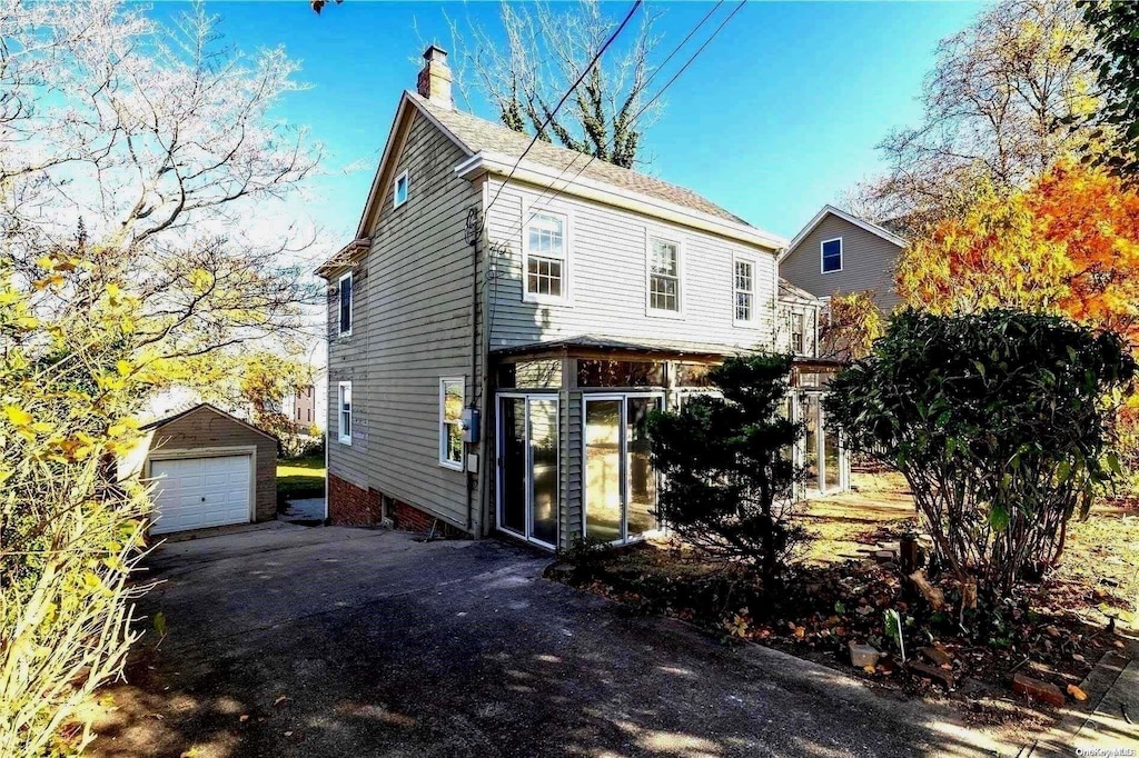 view of front of property featuring an outdoor structure and a garage