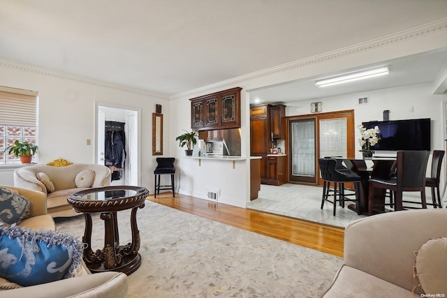 living room with light hardwood / wood-style floors and ornamental molding