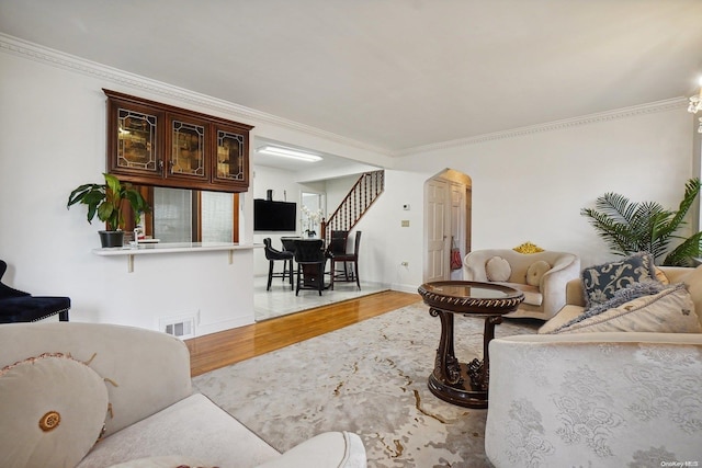 living room with light wood-type flooring and crown molding