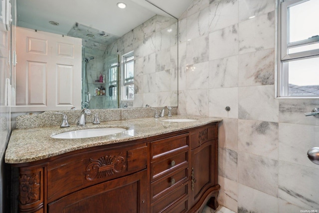 bathroom with vanity, tile walls, and walk in shower