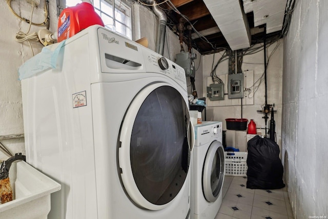 laundry room with washing machine and dryer, electric panel, and sink