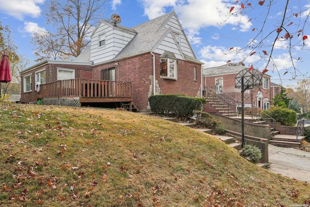 view of side of home with a yard and a deck