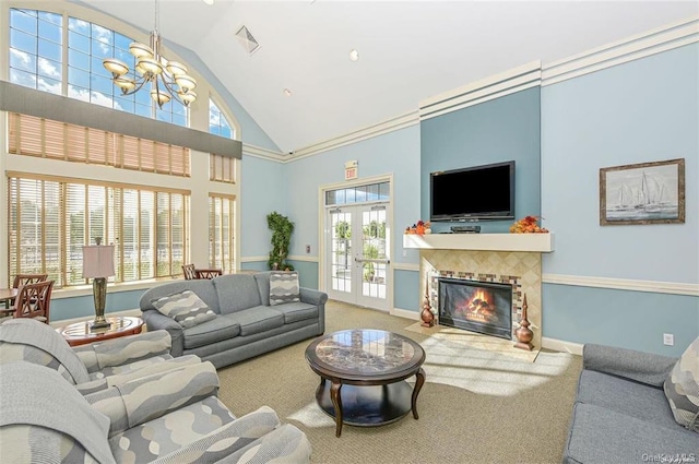 living room featuring carpet, a tiled fireplace, plenty of natural light, and high vaulted ceiling