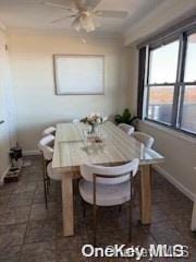 18-05 215th St Unit 16S, Bayside, NY 11360 - dining room featuring a ceiling fan, baseboards, and dark tile patterned flooring