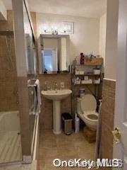 18-05 215th St Unit 16S, Bayside, NY 11360 - full bathroom featuring toilet and tile walls