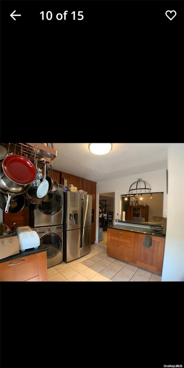 washroom with light tile patterned floors and stacked washer and dryer