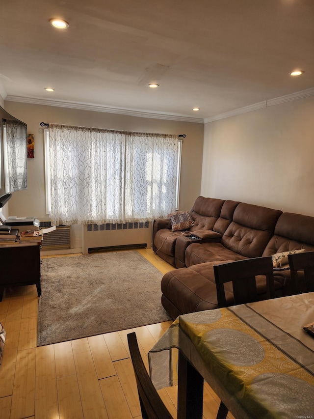 living room with ornamental molding, radiator, and light wood-type flooring