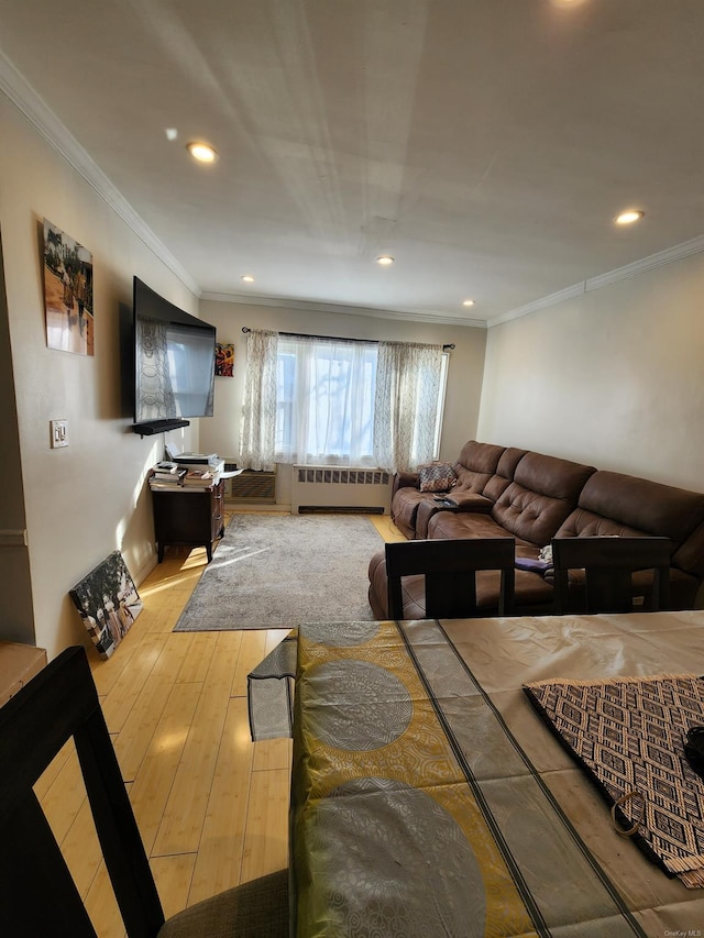 living room featuring crown molding, radiator heating unit, and light hardwood / wood-style flooring