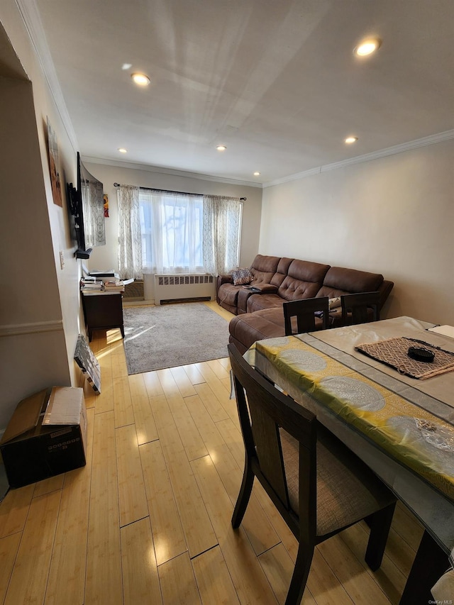 dining space with radiator, ornamental molding, and light hardwood / wood-style floors