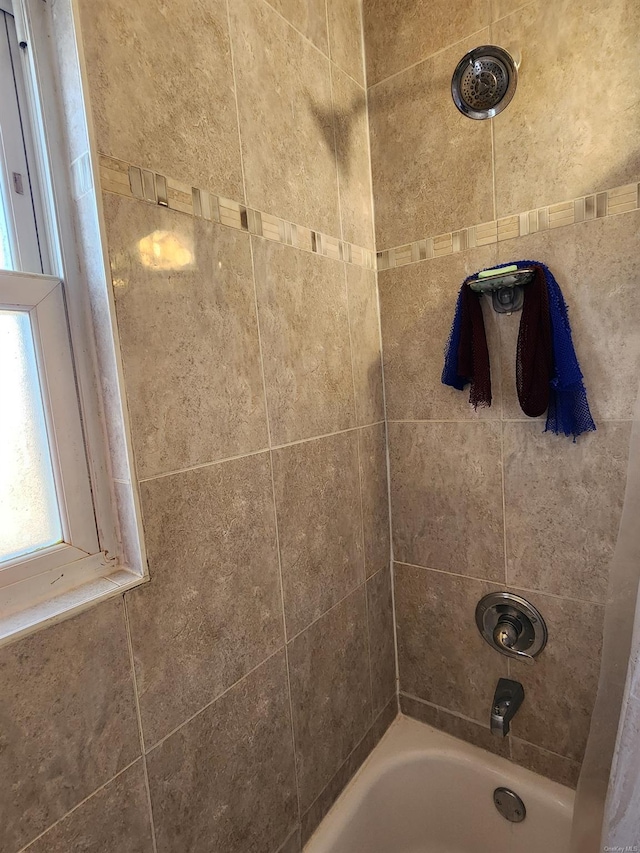 bathroom featuring tiled shower / bath