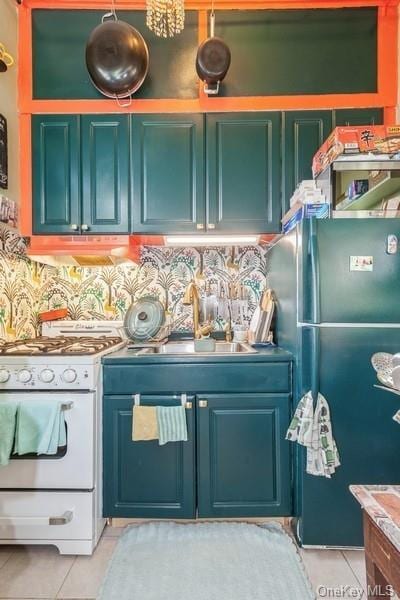 kitchen featuring decorative backsplash, stainless steel fridge, light tile patterned floors, and white range