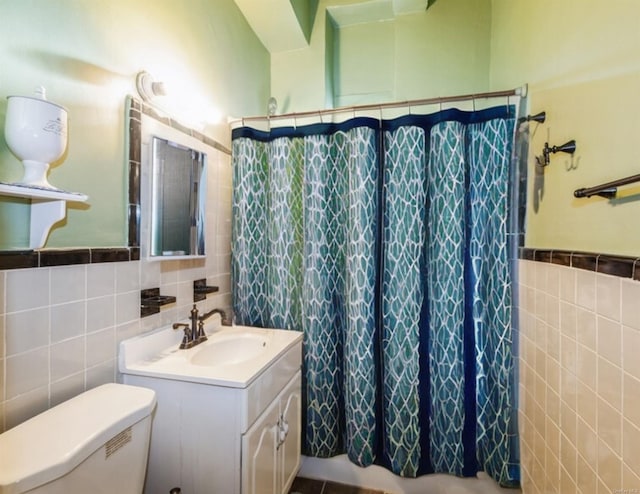 bathroom featuring tile walls, toilet, and walk in shower