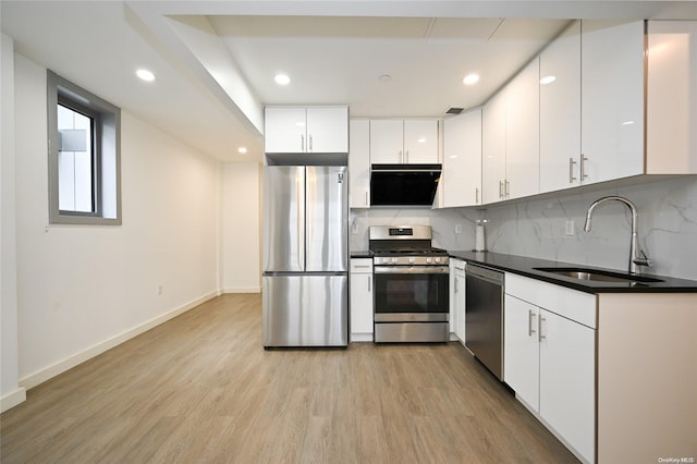 kitchen with white cabinetry, sink, stainless steel appliances, light hardwood / wood-style flooring, and extractor fan