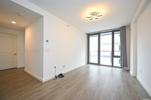 unfurnished room with hardwood / wood-style flooring