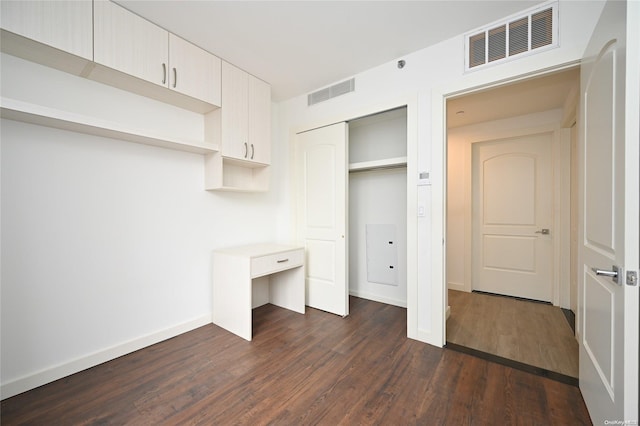 unfurnished bedroom featuring dark hardwood / wood-style flooring and a closet