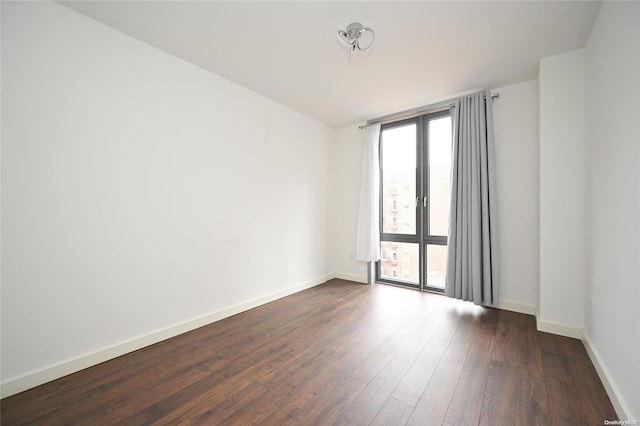 unfurnished room with dark hardwood / wood-style flooring