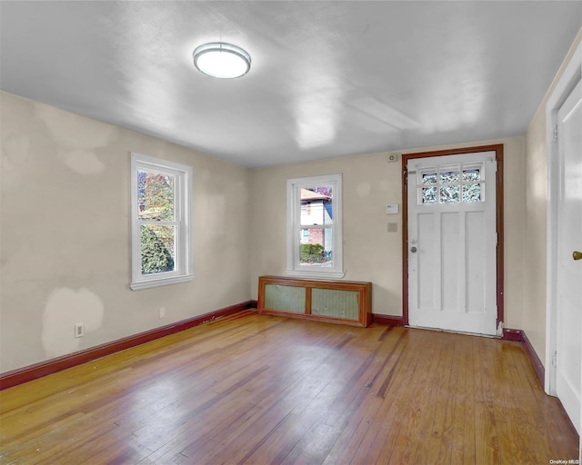 entryway featuring radiator heating unit, light hardwood / wood-style floors, and plenty of natural light