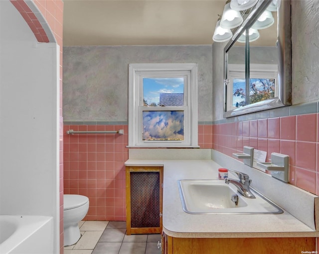 bathroom featuring a bathing tub, tile patterned flooring, toilet, vanity, and tile walls