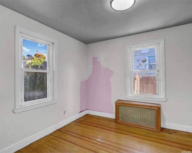 unfurnished room with hardwood / wood-style flooring