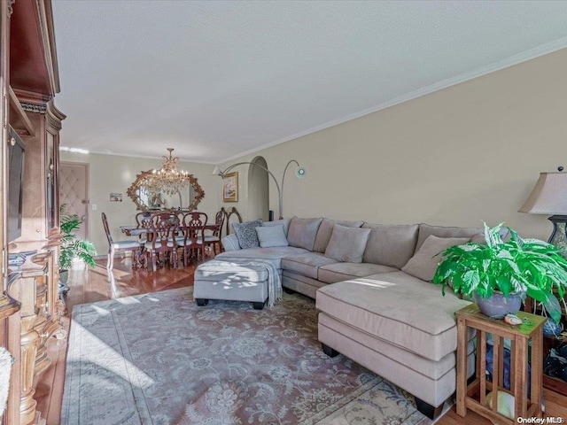 living room featuring hardwood / wood-style flooring, ornamental molding, and a chandelier