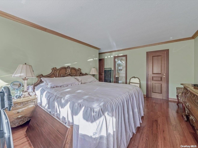 bedroom featuring hardwood / wood-style floors, crown molding, and a textured ceiling