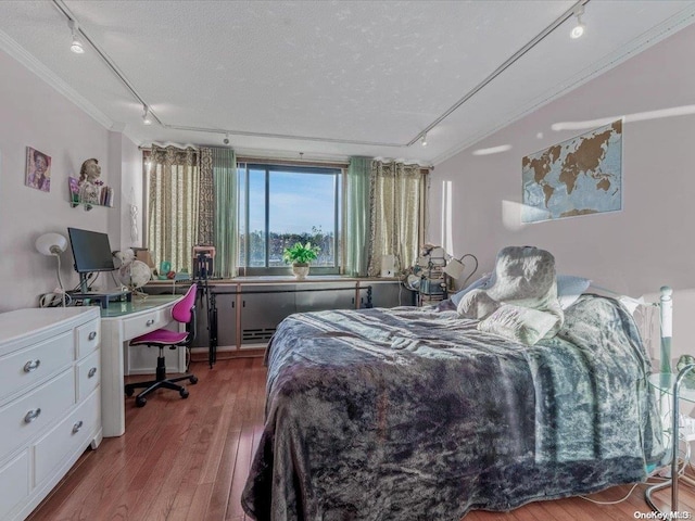 bedroom featuring hardwood / wood-style flooring, crown molding, a textured ceiling, and track lighting