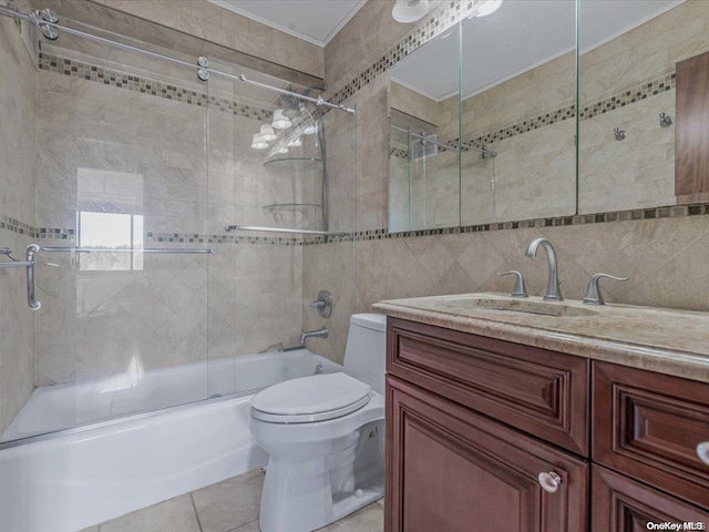 full bathroom with vanity, tile patterned floors, combined bath / shower with glass door, toilet, and tile walls