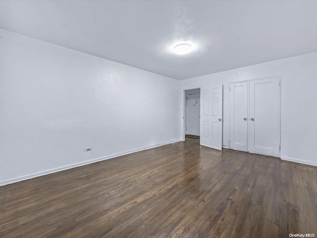 unfurnished bedroom with dark hardwood / wood-style flooring