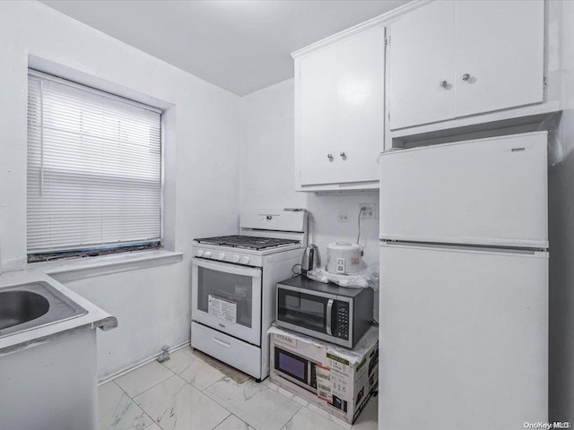 kitchen with sink, white cabinets, and white appliances