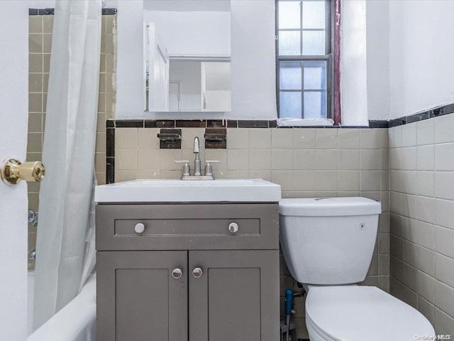 full bathroom with shower / bath combination with curtain, vanity, toilet, and tile walls